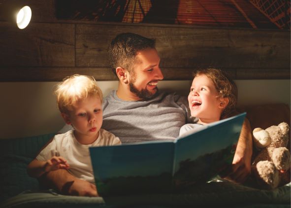 father with 2 boys reading